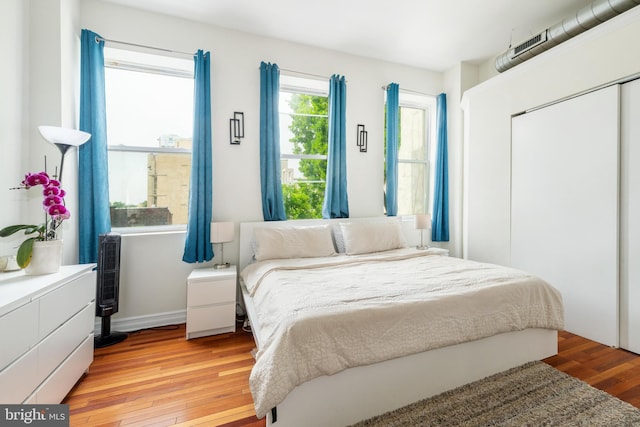 bedroom with light wood-style flooring and a closet