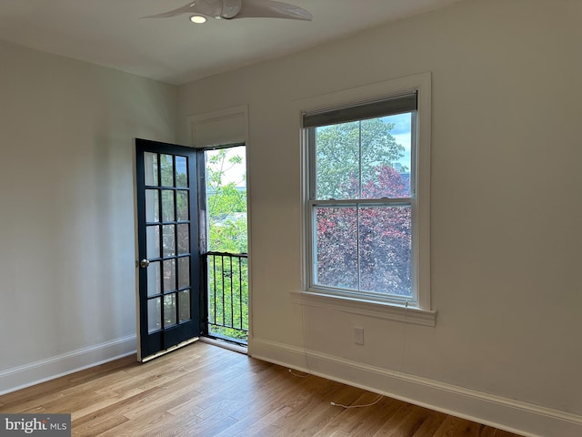 doorway to outside featuring baseboards, wood finished floors, and a ceiling fan