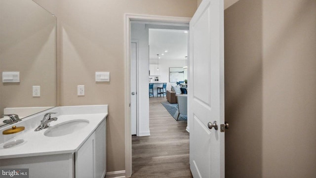 bathroom featuring wood finished floors, vanity, and baseboards
