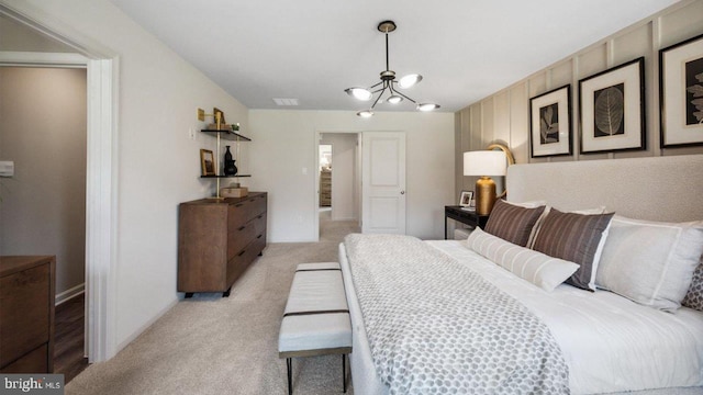 bedroom with light carpet, a chandelier, and baseboards