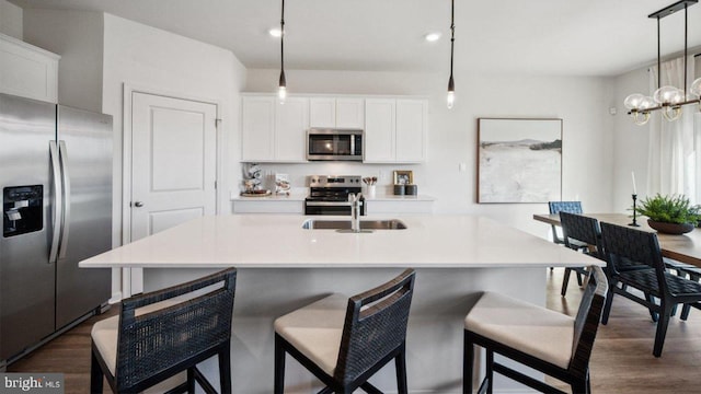 kitchen with appliances with stainless steel finishes, a sink, dark wood-type flooring, white cabinets, and recessed lighting