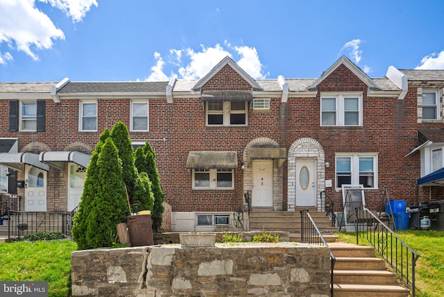 townhome / multi-family property with brick siding and fence