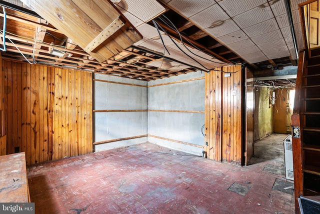 unfinished basement featuring wooden walls