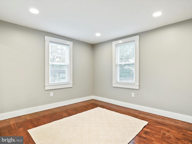 unfurnished room featuring baseboards, dark wood-style flooring, and recessed lighting