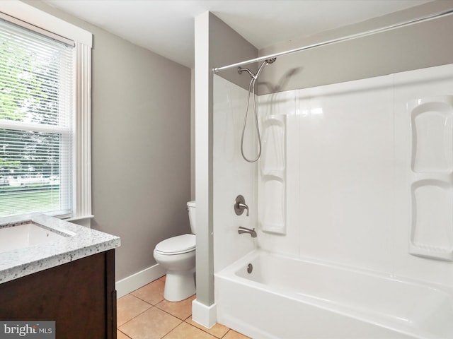 bathroom with tile patterned floors, baseboards, toilet, vanity, and shower / washtub combination