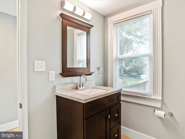 bathroom with healthy amount of natural light, baseboards, and vanity