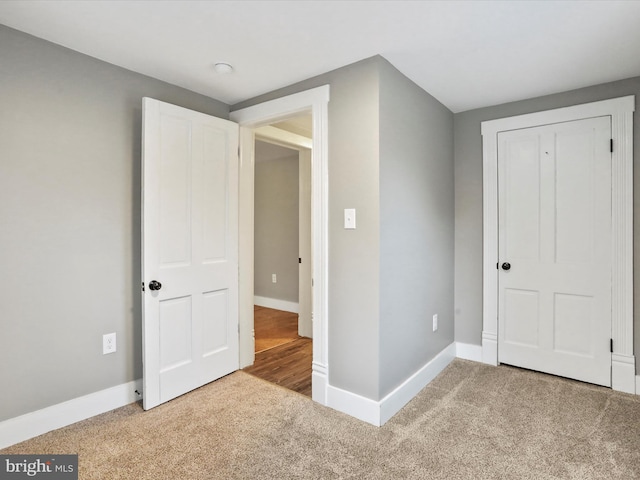unfurnished bedroom featuring carpet floors and baseboards