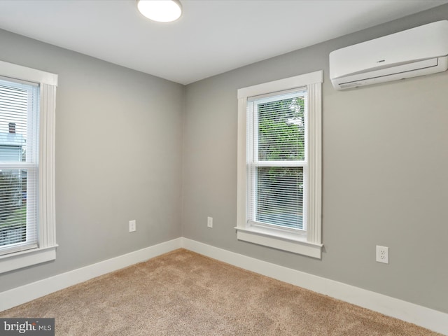 carpeted spare room with a wall mounted AC and baseboards