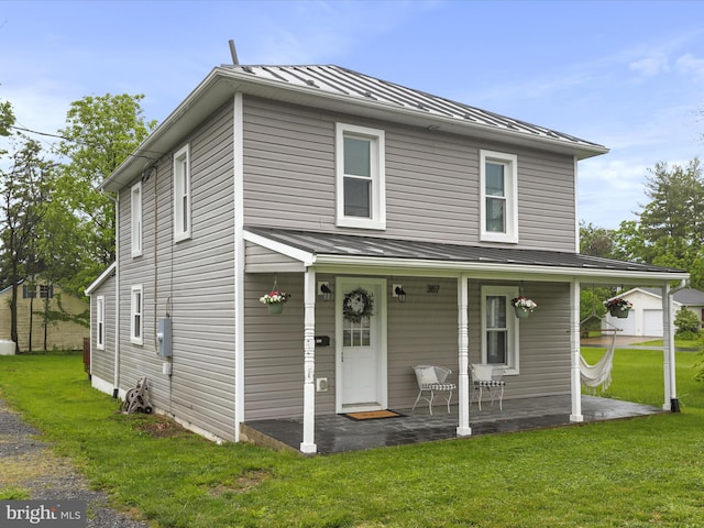 view of front of house featuring a standing seam roof, metal roof, a porch, and a front lawn