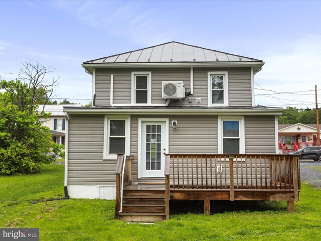 back of house featuring a standing seam roof, a deck, a yard, ac unit, and metal roof