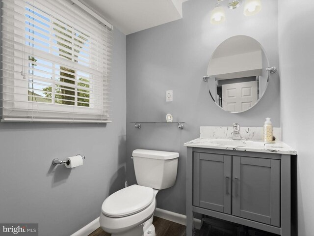 101 Gothard Rd, Lutherville Timonium, MD 21093 - bathroom with baseboards, toilet, vanity, and wood finished floors