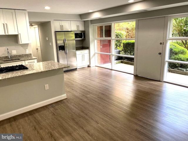 3419 University Blvd W Unit 102, Kensington, MD 20895 - kitchen with stainless steel appliances, a sink, dark wood-style floors, light stone counters, and white cabinets