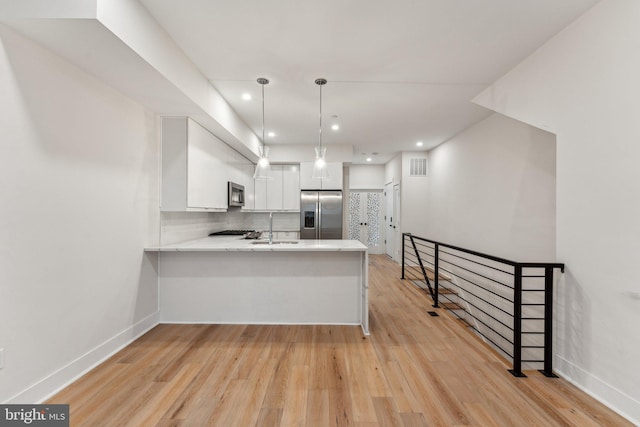 1645 W Virginia NE Unit 1, Washington, DC 20002 - kitchen featuring stainless steel appliances, a sink, white cabinets, light wood-style flooring, and light countertops
