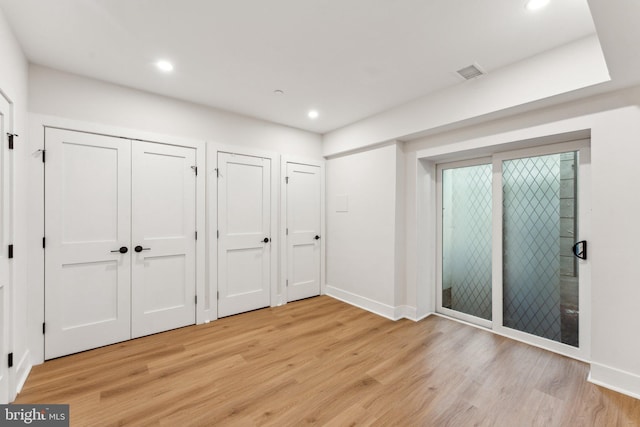 1645 W Virginia NE Unit 1, Washington, DC 20002 - unfurnished bedroom with two closets, light wood-style floors, recessed lighting, and baseboards