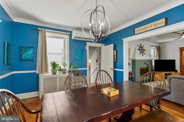dining room with a chandelier, crown molding, baseboards, a fireplace, and ceiling fan