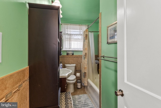 bathroom with toilet, shower / bath combo, vanity, tile patterned flooring, and wainscoting