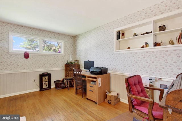 office area with a wainscoted wall, hardwood / wood-style flooring, and wallpapered walls