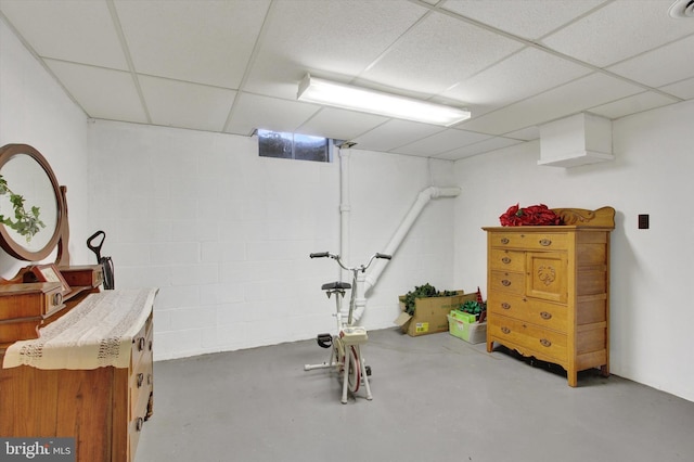 workout room featuring a drop ceiling and concrete block wall