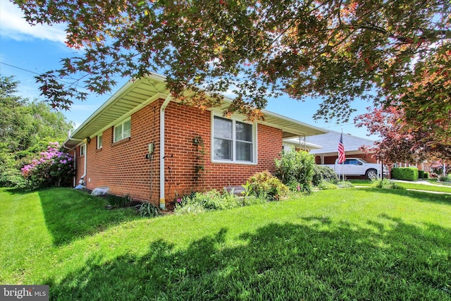 view of side of property featuring a lawn and brick siding