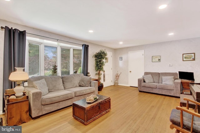 living room with recessed lighting, light wood-type flooring, and baseboards