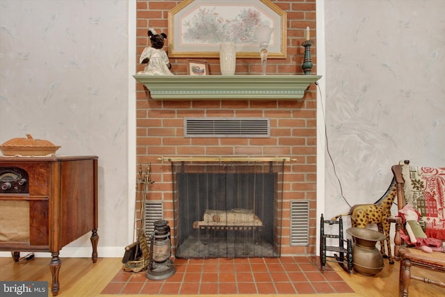 detailed view of a fireplace, wood finished floors, wallpapered walls, and baseboards