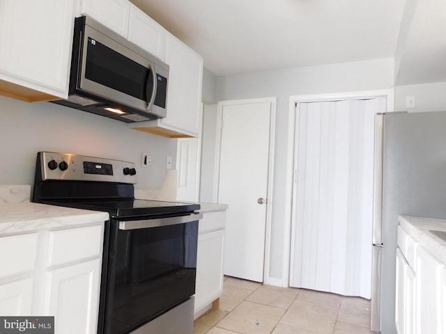 kitchen featuring stainless steel appliances, white cabinets, and light tile patterned floors