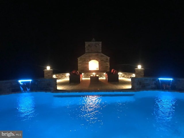 8170 Hollow Rd, Middletown, MD 21769 - pool at twilight with a fireplace, an outdoor pool, and a patio