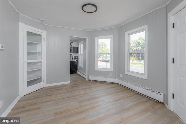 127 N Broad St, Penns Grove, NJ 08069 - spare room with baseboard heating, light wood finished floors, crown molding, a decorative wall, and baseboards