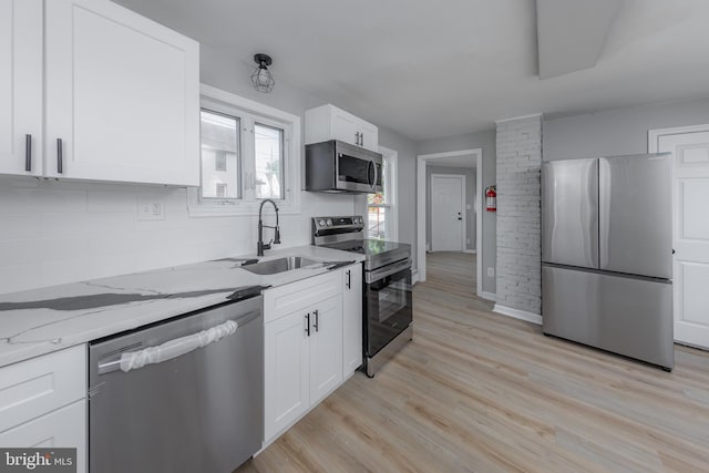 127 N Broad St, Penns Grove, NJ 08069 - kitchen with appliances with stainless steel finishes, a sink, light wood finished floors, backsplash, and light stone countertops
