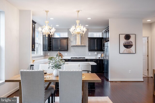 501 Triggerfish Dr, Oxon Hill, MD 20745 - kitchen featuring wall chimney range hood, a chandelier, freestanding refrigerator, dark wood finished floors, and light countertops