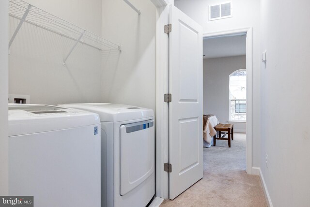 501 Triggerfish Dr, Oxon Hill, MD 20745 - washroom featuring light carpet, washer and clothes dryer, and baseboards