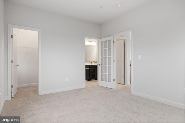 501 Triggerfish Dr, Oxon Hill, MD 20745 - unfurnished bedroom with french doors, light carpet, a spacious closet, and baseboards