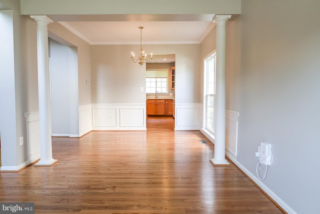720 Beehive Way, Winchester, VA 22601 - unfurnished dining area with wood finished floors, ornate columns, a sink, crown molding, and wainscoting
