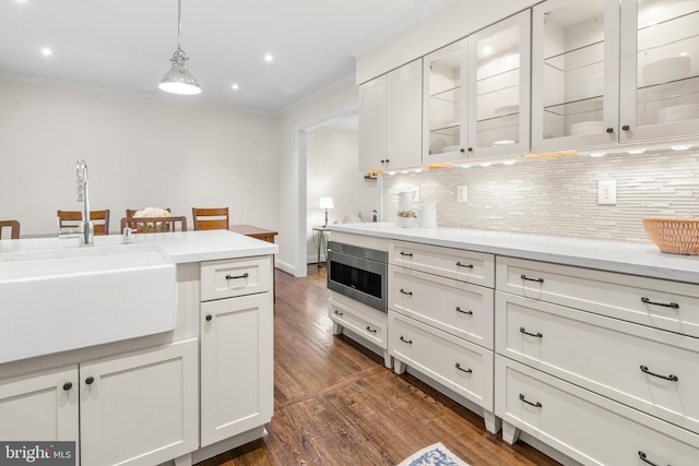 255 Lower Magothy Beach Rd, Severna Park, MD 21146 - kitchen featuring a sink, dark wood-style floors, backsplash, stainless steel microwave, and light countertops