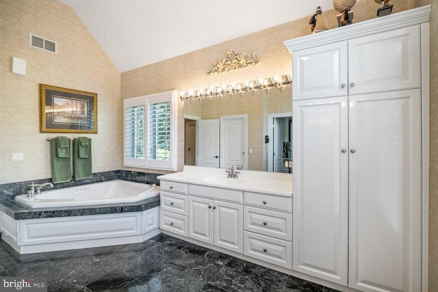full bath featuring vaulted ceiling, vanity, a bath, and marble tiled flooring