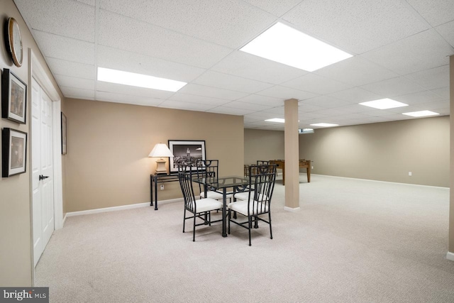 dining space featuring carpet flooring, a paneled ceiling, and baseboards