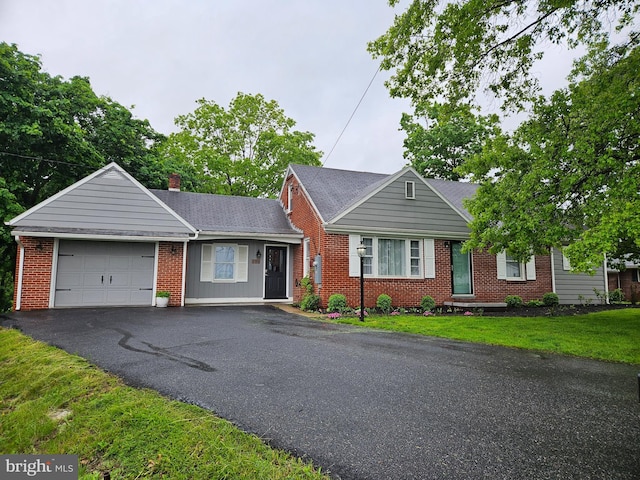 151 Amsley Dr, Chambersburg, PA 17202 - view of front of house with brick siding, a garage, asphalt driveway, a front yard, and a chimney