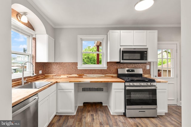 2811 Westfield Ave, Baltimore, MD 21214 - kitchen with stainless steel appliances, butcher block counters, crown molding, white cabinets, and tasteful backsplash