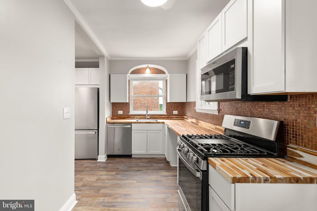 2811 Westfield Ave, Baltimore, MD 21214 - kitchen featuring appliances with stainless steel finishes, butcher block countertops, backsplash, light wood-style flooring, and white cabinets