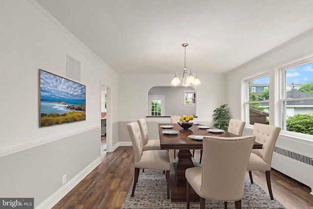2811 Westfield Ave, Baltimore, MD 21214 - dining room featuring radiator, dark wood-style floors, a chandelier, crown molding, and arched walkways