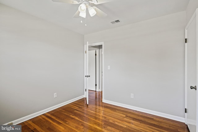 empty room featuring baseboards, wood finished floors, and a ceiling fan