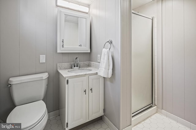 full bath with a stall shower, toilet, vanity, and tile patterned floors