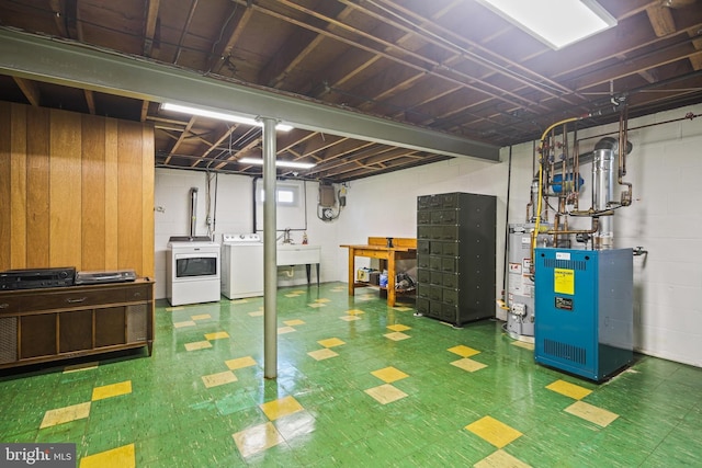 basement featuring washing machine and dryer, tile patterned floors, gas water heater, and a heating unit