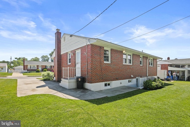view of property exterior with a chimney, a yard, and brick siding