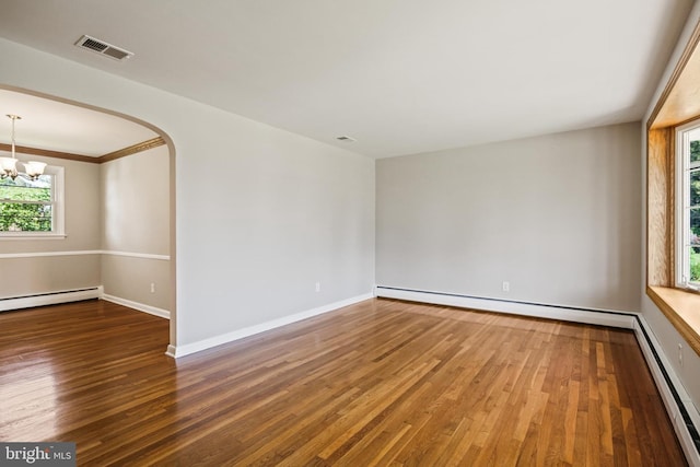unfurnished room with a baseboard heating unit, a baseboard radiator, wood finished floors, and plenty of natural light