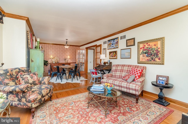 living area with ornamental molding, wood finished floors, and baseboards