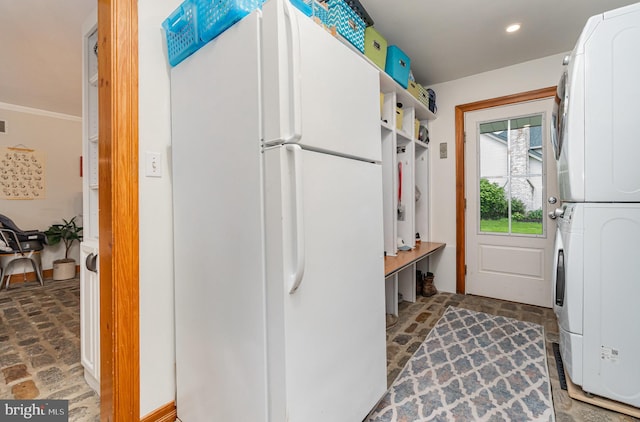 mudroom with stacked washer and clothes dryer, brick patterned floors, and recessed lighting
