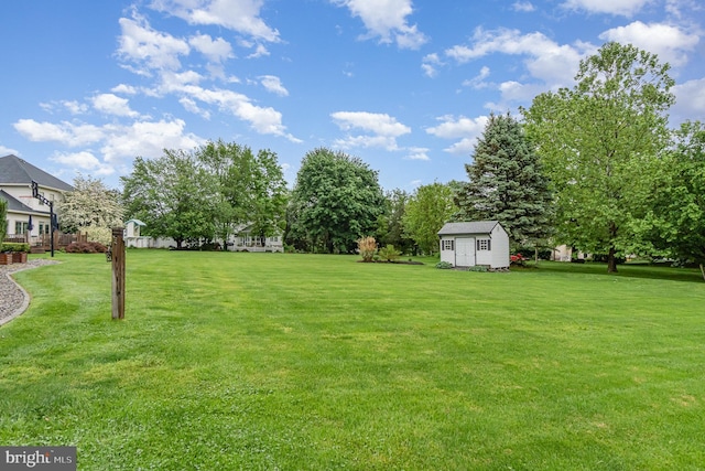 view of grassy yard with a storage unit and an outbuilding