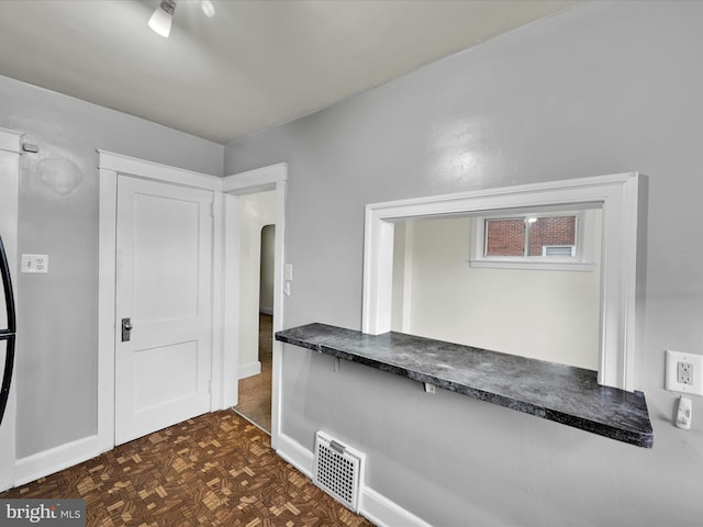 foyer with arched walkways and baseboards