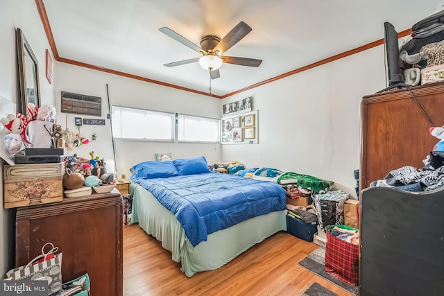 bedroom featuring crown molding, wood finished floors, and a ceiling fan